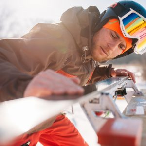 Male skier checks skis before skiing, winter sport